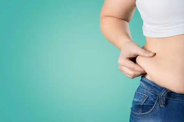 Image of woman pinching her love handles to show weight gain Malvern Wells